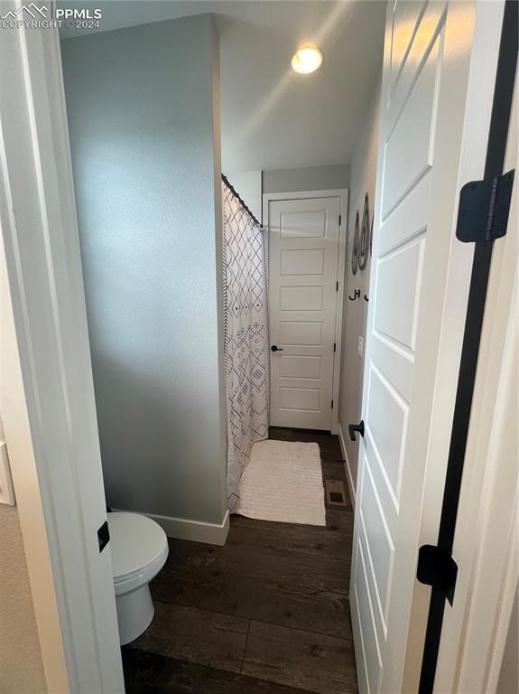 bathroom with hardwood / wood-style floors and toilet