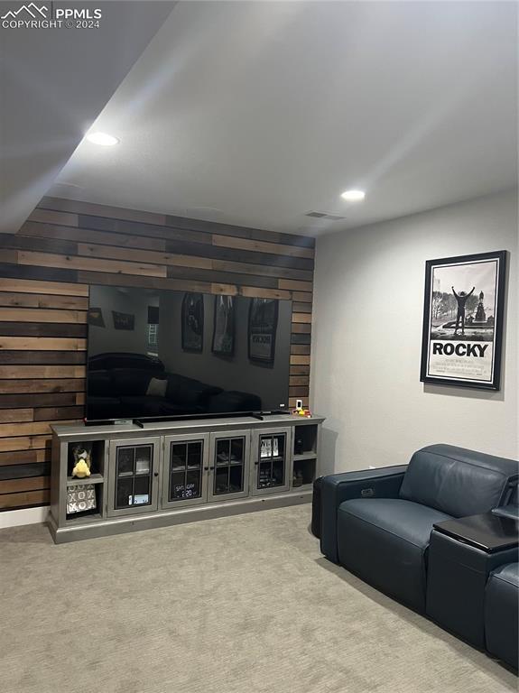 living room featuring carpet flooring and wooden walls