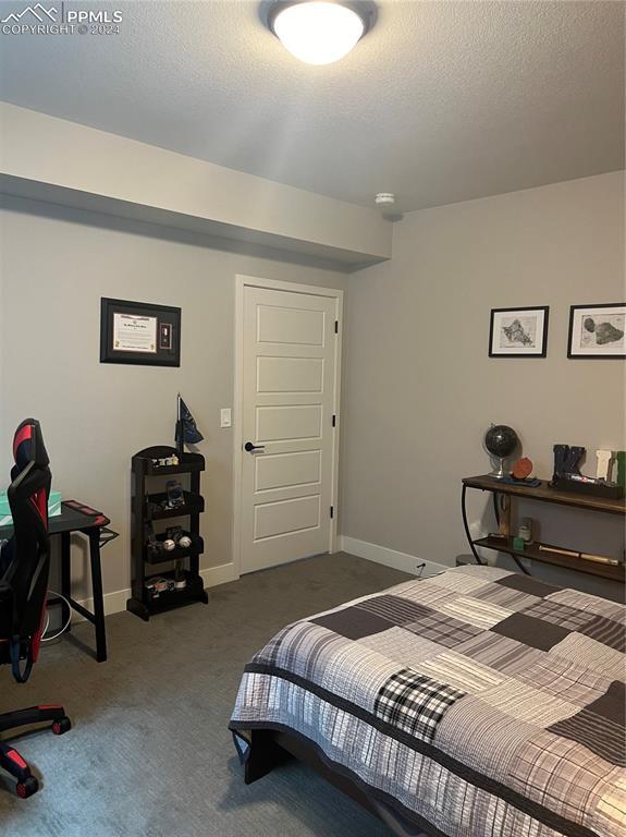 bedroom featuring dark carpet and a textured ceiling