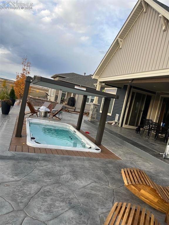 view of pool featuring a jacuzzi and a patio