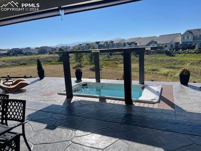 view of swimming pool featuring a patio area and an outdoor hot tub