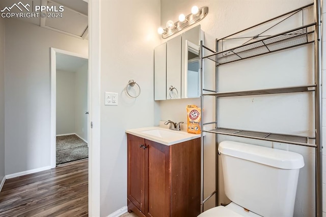 bathroom with vanity, wood-type flooring, and toilet