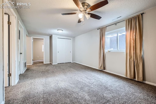 unfurnished bedroom featuring a textured ceiling, carpet floors, a closet, and ceiling fan