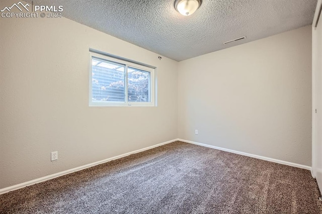 carpeted spare room with a textured ceiling