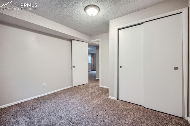 unfurnished bedroom featuring carpet floors, a textured ceiling, and a closet