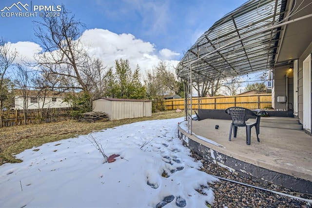 yard layered in snow with a storage shed