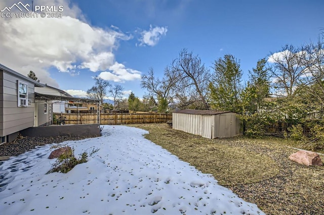 yard covered in snow featuring a storage unit