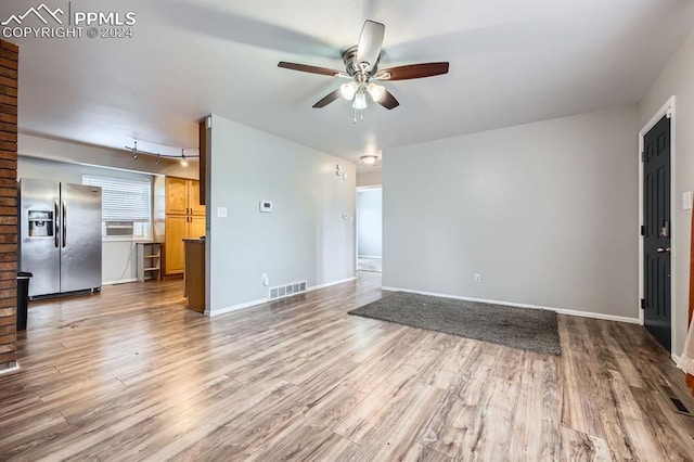 unfurnished living room featuring ceiling fan and light hardwood / wood-style floors