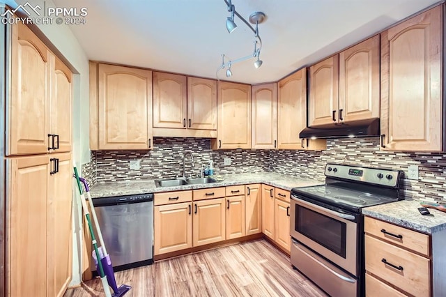 kitchen featuring appliances with stainless steel finishes, rail lighting, backsplash, sink, and light brown cabinets