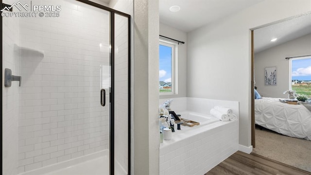 13358 Savannah Falls Ct, Peyton, CO 80831 - full bath with ensuite bathroom, a bath, a shower stall, wood finished floors, and vaulted ceiling