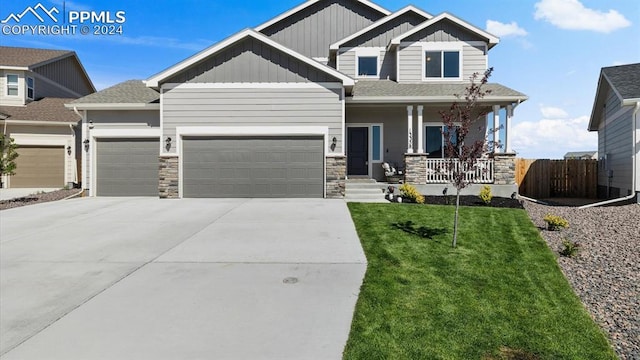 13358 Savannah Falls Ct, Peyton, CO 80831 - craftsman-style home with driveway, covered porch, board and batten siding, a front lawn, and a garage