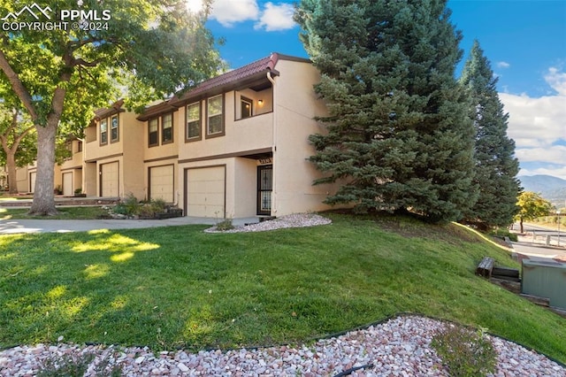 view of front of property with a garage and a front lawn