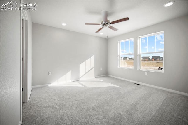 carpeted spare room with ceiling fan