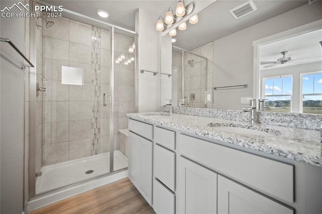 bathroom with hardwood / wood-style floors, ceiling fan, and a shower with door