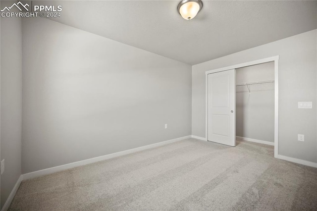 unfurnished bedroom featuring carpet floors and a closet