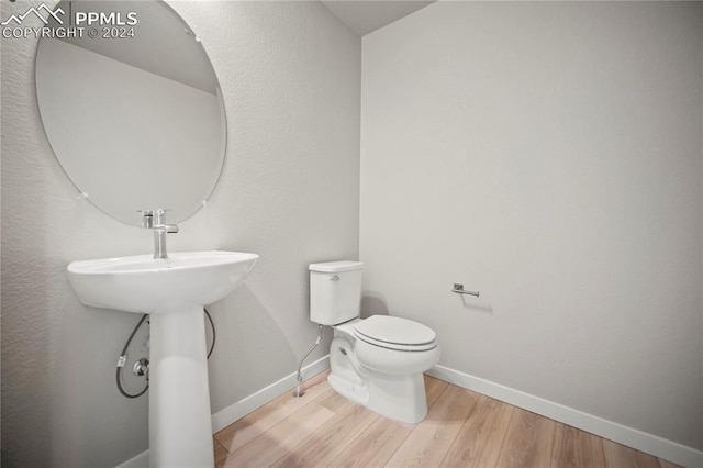 bathroom with hardwood / wood-style flooring and toilet