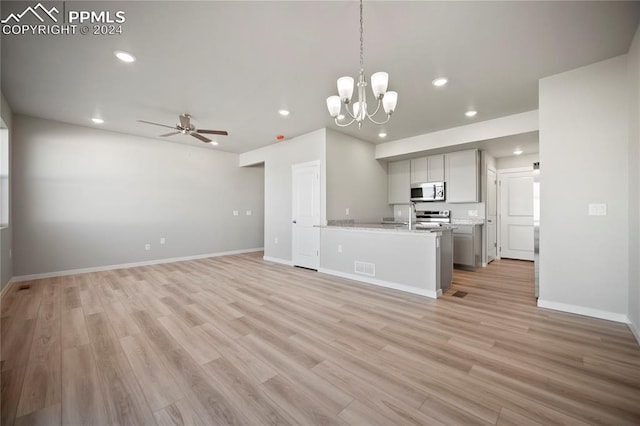 kitchen featuring pendant lighting, ceiling fan with notable chandelier, light hardwood / wood-style flooring, gray cabinets, and stainless steel appliances