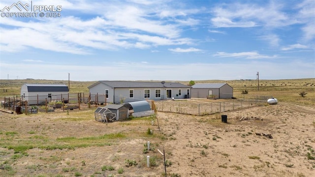 rear view of house featuring an outbuilding and a rural view