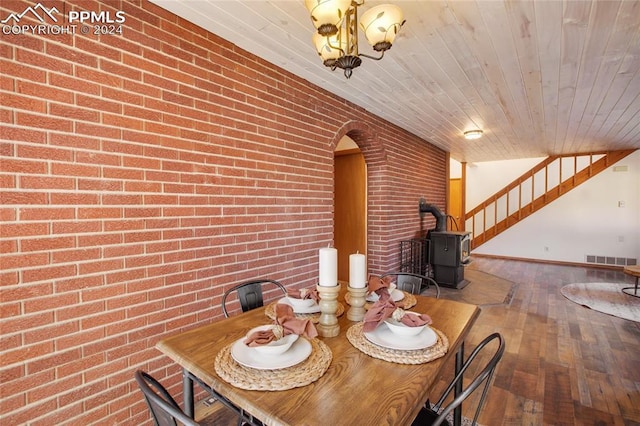 unfurnished dining area featuring hardwood / wood-style flooring, a wood stove, brick wall, and wooden ceiling