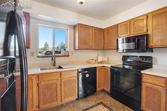 kitchen featuring light tile patterned floors, sink, and black appliances