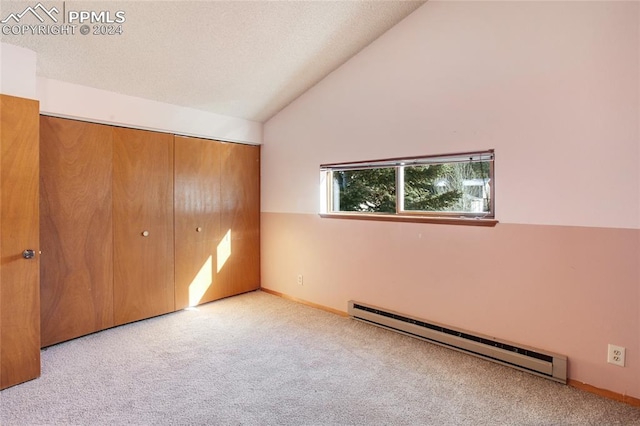 unfurnished bedroom featuring a baseboard radiator, vaulted ceiling, a closet, and light colored carpet