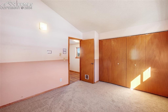 unfurnished room with light carpet and lofted ceiling