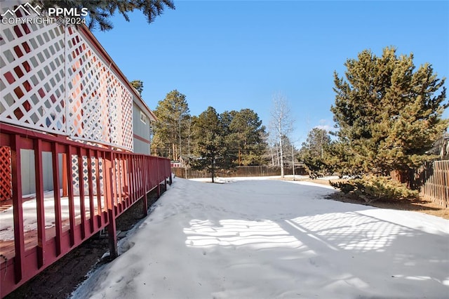 snowy yard featuring a wooden deck