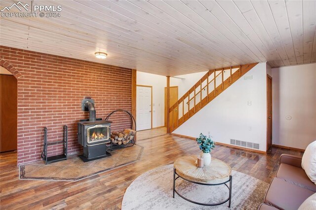 living room featuring wood-type flooring, a wood stove, and wood ceiling