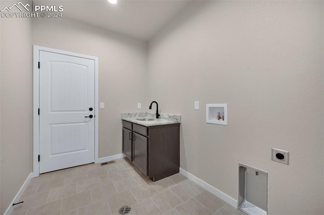 clothes washing area with cabinets, washer hookup, electric dryer hookup, sink, and light tile patterned floors