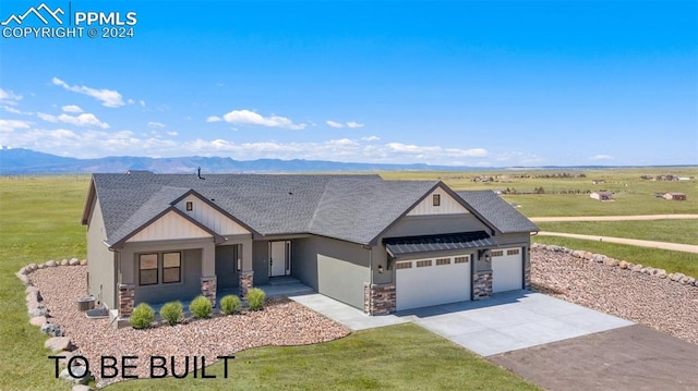 view of front facade with a mountain view, a garage, and a front yard