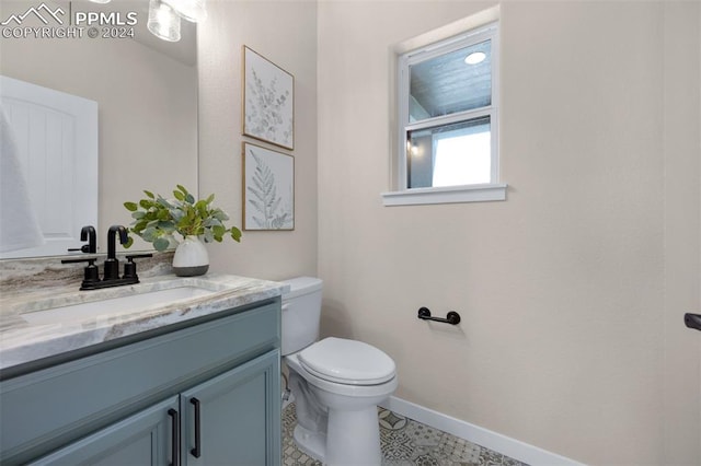 bathroom with tile patterned flooring, vanity, and toilet