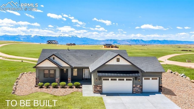 view of front of home featuring a mountain view, a garage, and a front lawn