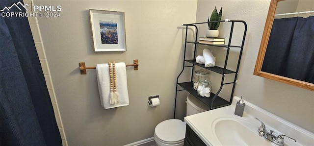 bathroom featuring vanity, toilet, and walk in shower