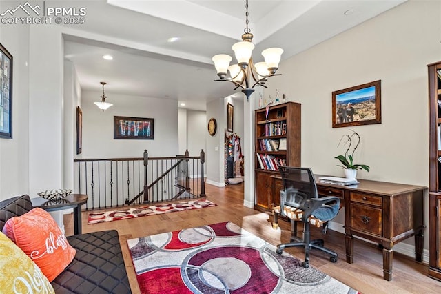 home office with light wood-type flooring and a notable chandelier