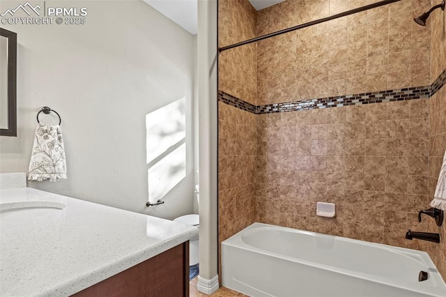 full bathroom with vanity, tiled shower / bath combo, and toilet