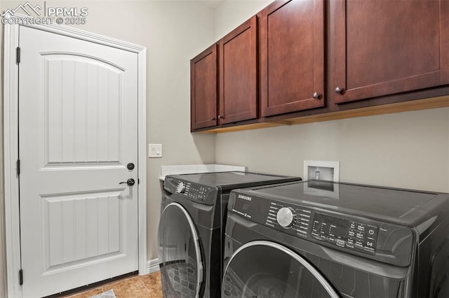 laundry area with washer and clothes dryer, light tile patterned flooring, and cabinets