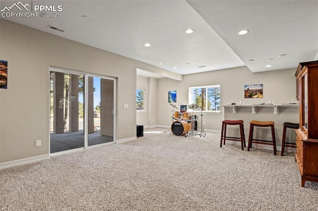 living area with plenty of natural light and light colored carpet