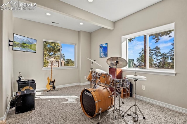 misc room featuring beamed ceiling, plenty of natural light, and carpet