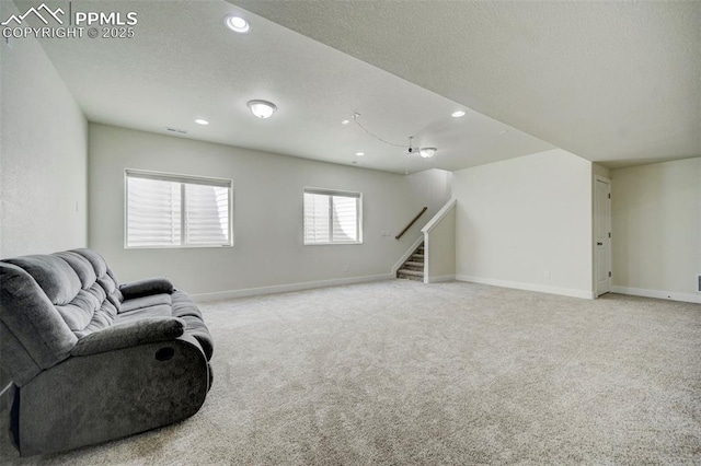 living area with light colored carpet and a textured ceiling