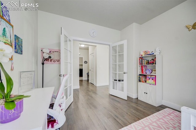 bedroom with french doors and hardwood / wood-style flooring