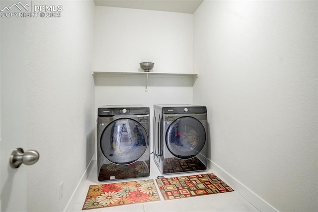 laundry room featuring tile patterned flooring and washer and clothes dryer