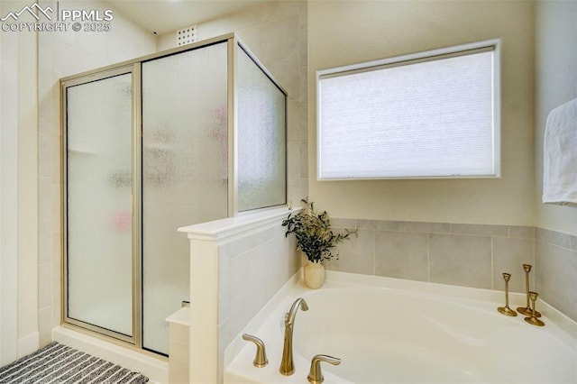 bathroom with a healthy amount of sunlight and shower with separate bathtub