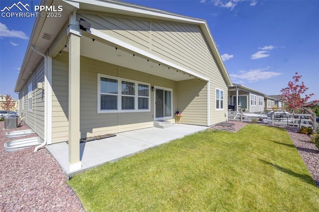 back of house with a lawn, a patio area, and cooling unit