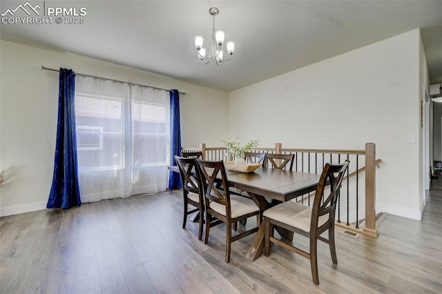 dining room with hardwood / wood-style floors and an inviting chandelier