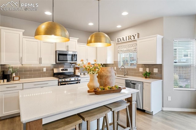 kitchen featuring pendant lighting, white cabinetry, and appliances with stainless steel finishes