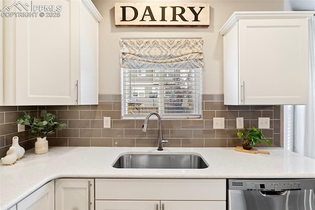 kitchen with dishwasher, white cabinetry, sink, and tasteful backsplash