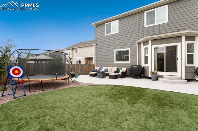 rear view of house featuring a yard, an outdoor hangout area, a trampoline, and a patio area