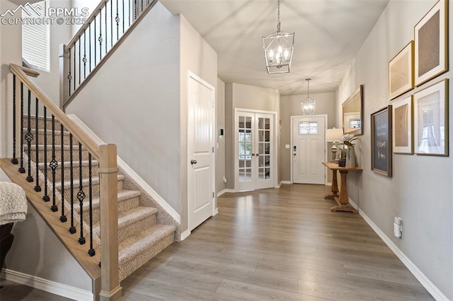 entrance foyer with hardwood / wood-style floors and a notable chandelier