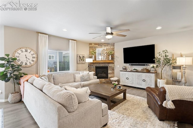 living room with ceiling fan, a fireplace, and wood-type flooring