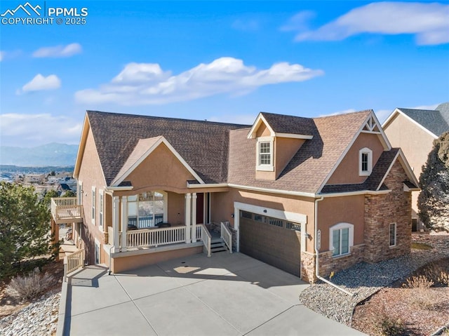 view of front of property with covered porch, a mountain view, and a garage